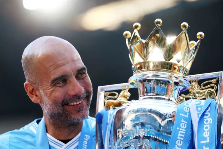 Manchester City manager Pep Guardiola celebrates with the trophy after winning the Premier League in 2024