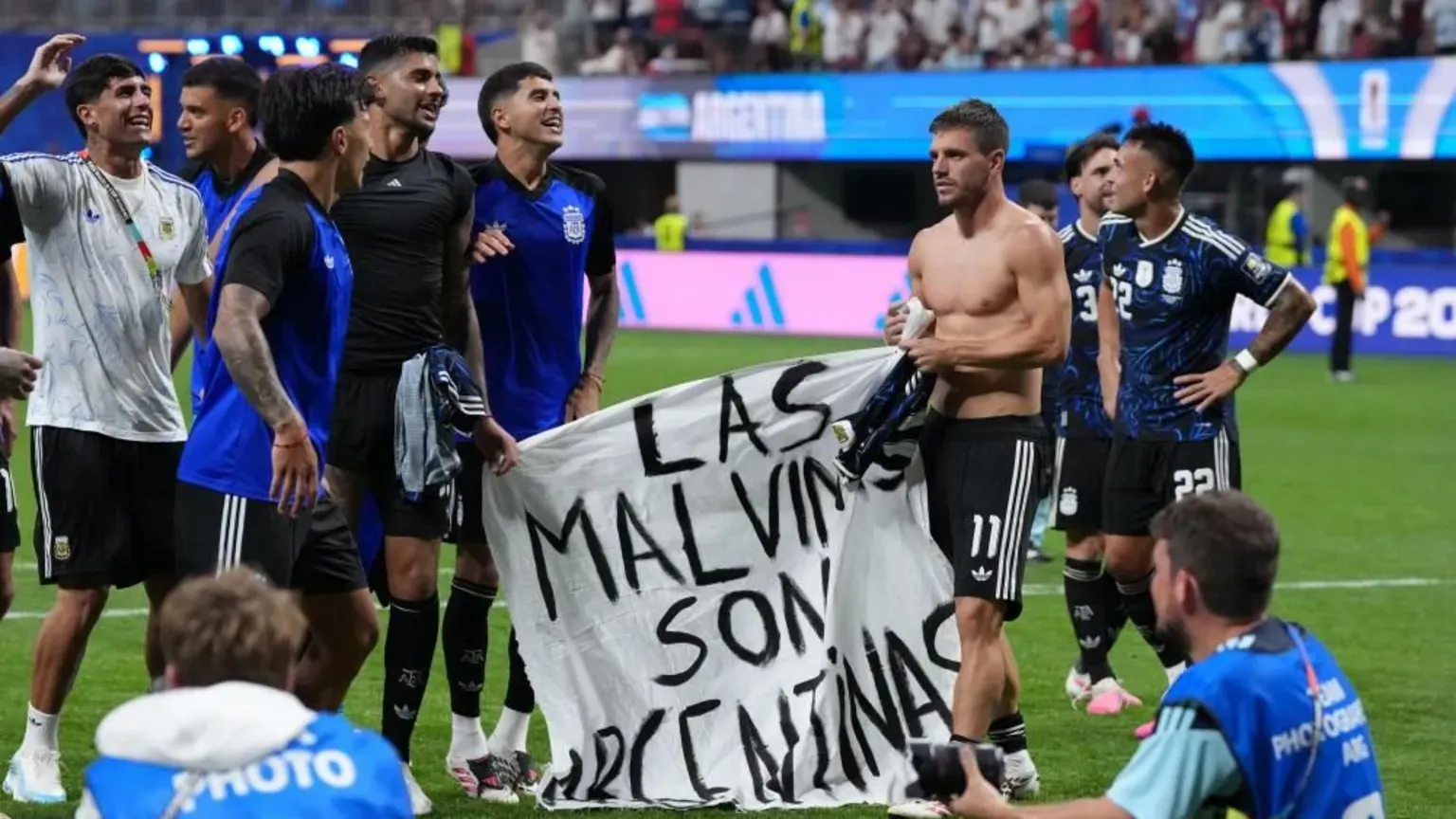 PA Media Several Argentinian football players standing on a pitch holding a banner saying "Las Malvinas Son Argentinas"