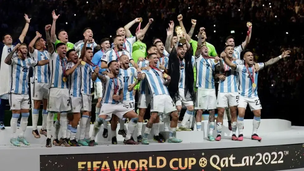 The Argentina squad celebrates with Lionel Messi lifting the Fifa World Cup trophy in Qatar