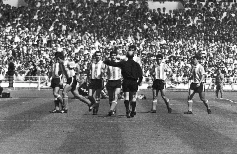 West German referee Rudolf Kreitlein (back to camera) talks to a line up of Argentine players after sending Antonio Rattin from the field